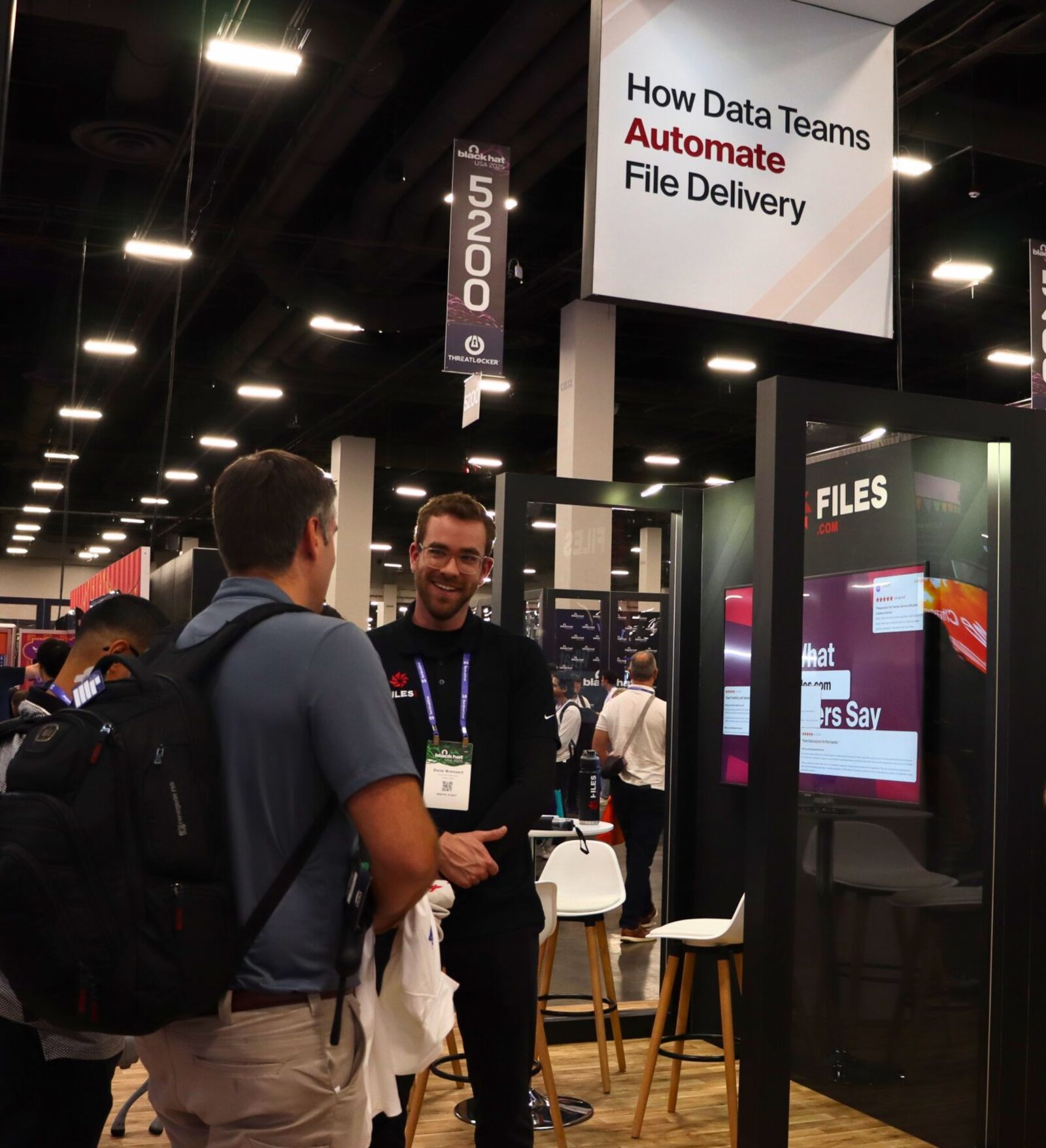 A Files.com team member chatting with a prospect at the company's industry-event booth.