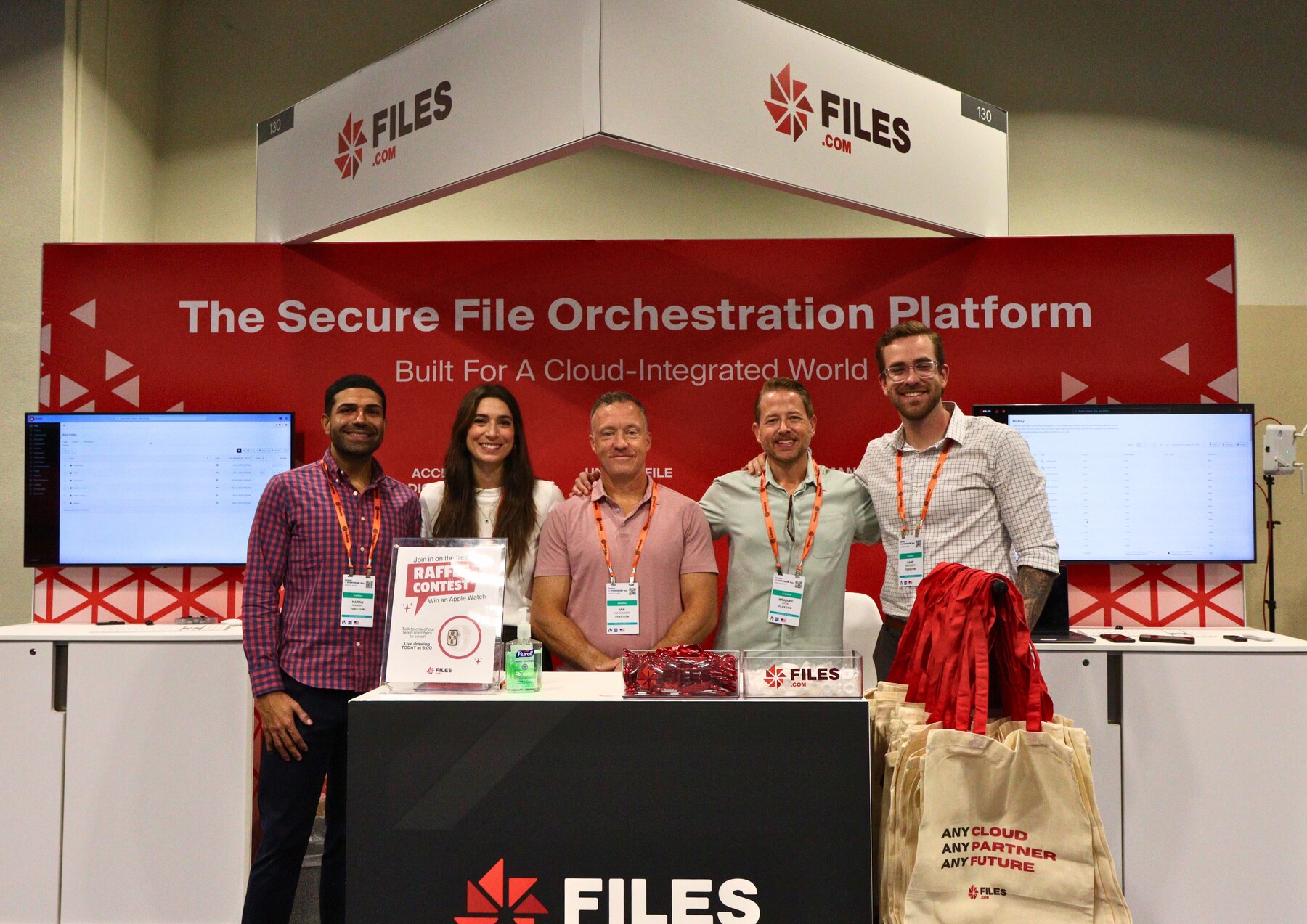 A Files.com team posed at the company's branded booth at the Gartner 2025 conference, beneath The Secure File Orchestration Platform banner.