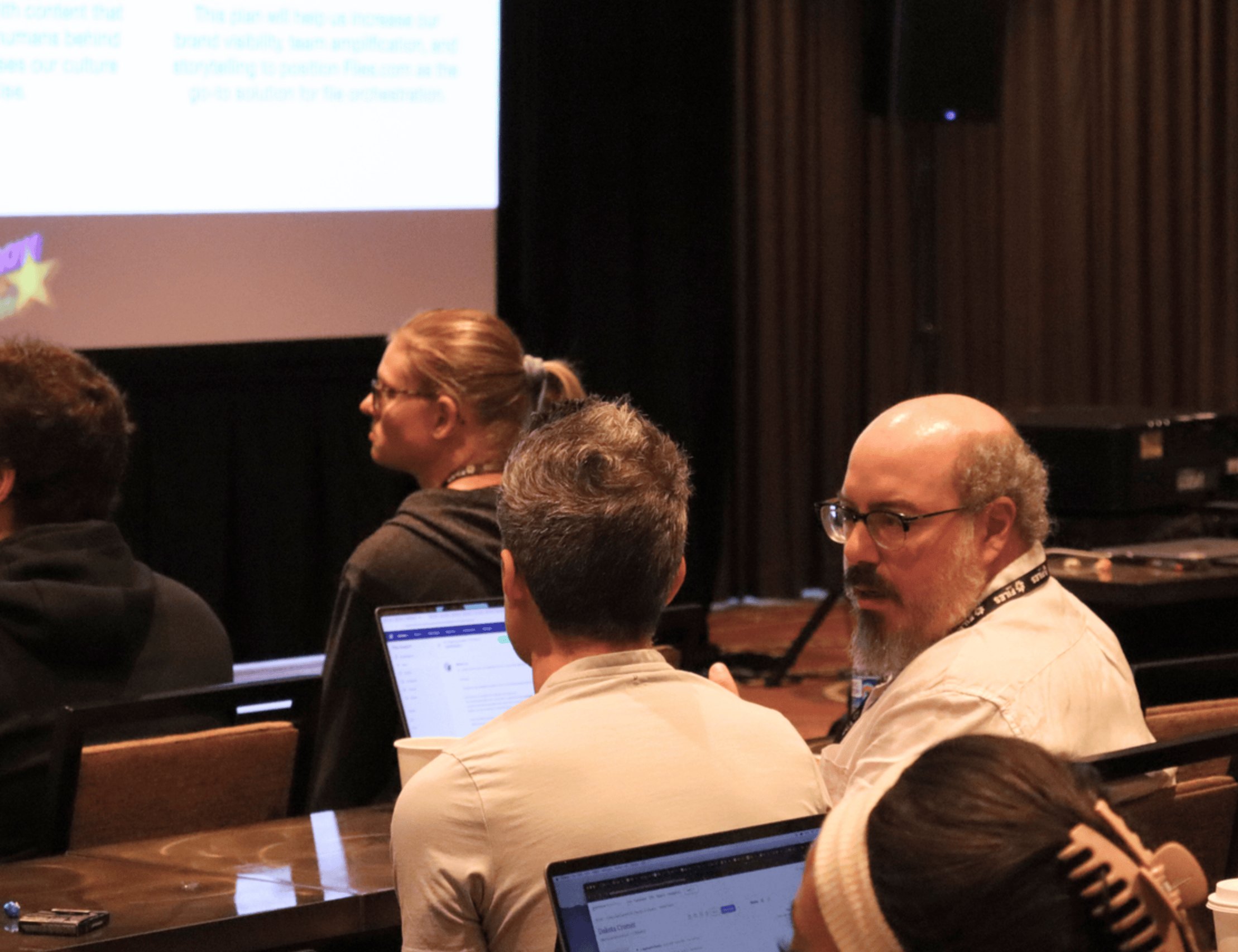 Adam taking notes during a Files.com strategy session, projector slides visible behind him.