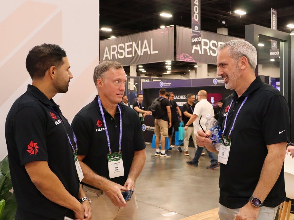 Wade Callison talking with Ian Waggoner and Karan Mangat in Files.com polos at a conference booth.